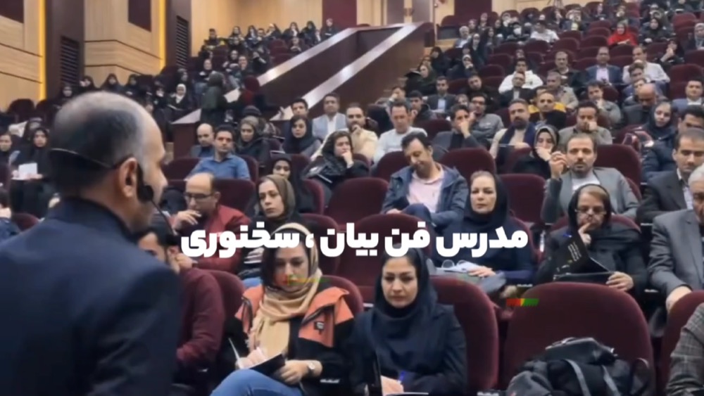 مهدی صادقلو در حال سخنرانی مقابل سالن پر از مخاطب